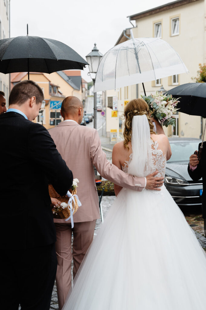 Brautpaar unter Regenschirm vor dem Rathaus Wanzleben 